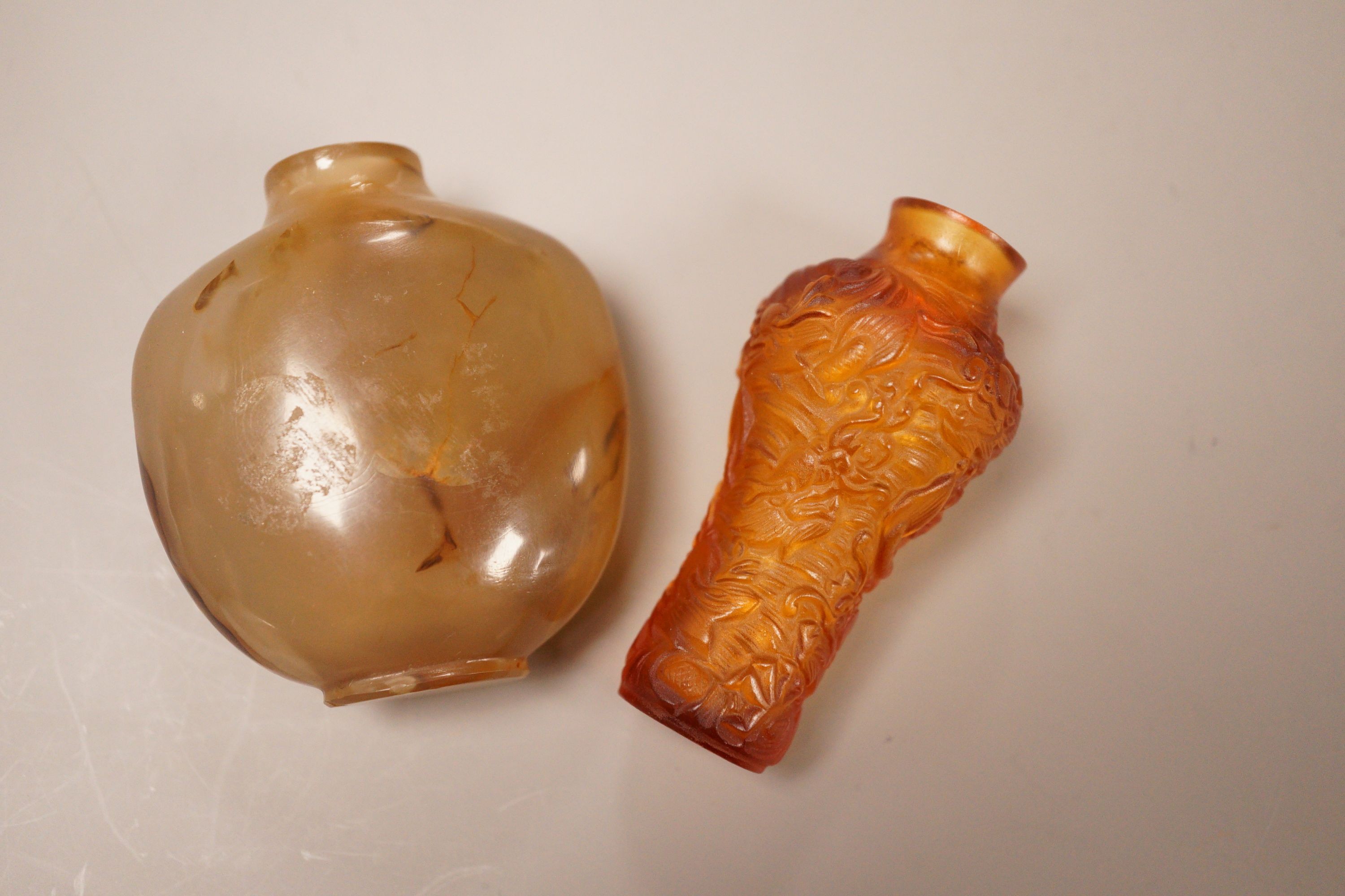 A Chinese agate snuff bottle and an amber glass snuff bottle